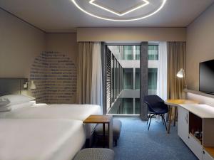 克洛滕Hyatt Place Zurich Airport the Circle的配有一张床、一张书桌和一扇窗户的酒店客房