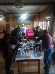 Bou Drarar阿瓦尤酒店的一群人站在桌子旁吃着食物