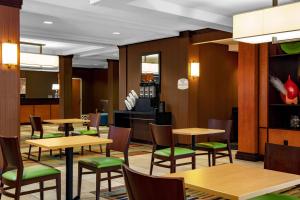 奥古斯塔Fairfield by Marriott Inn and Suites Augusta Fort Eisenhower Area的餐厅设有木桌和绿色椅子