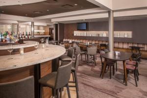 林夕昆高地巴尔的摩华盛顿国际机场万怡酒店的一间带桌椅的餐厅和一间酒吧