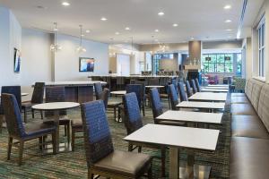 休斯顿Residence Inn by Marriott Houston West/Beltway 8 at Clay Road的一间带桌椅的用餐室和一间自助餐厅