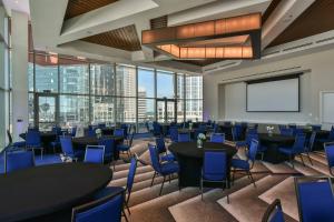 夏洛特SpringHill Suites by Marriott Charlotte City Center的一间会议室,配有桌椅和投影屏幕