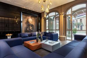柏林Hotel Luc, Autograph Collection的客厅配有蓝色的沙发和桌子