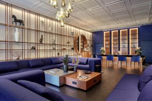 柏林Hotel Luc, Autograph Collection的客厅配有紫色沙发和桌子