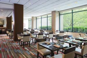 赫恩登华盛顿杜勒斯万豪套房酒店的餐厅设有桌椅和大窗户。