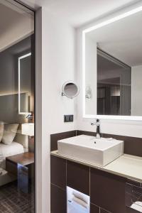 沃尔夫斯堡沃尔夫斯堡万怡酒店的浴室设有白色水槽和镜子