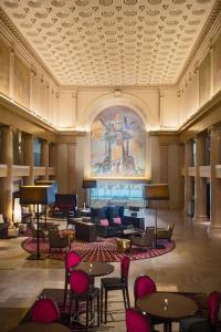 丹佛丹佛市中心万丽酒店的大堂设有桌椅和墙上的绘画作品