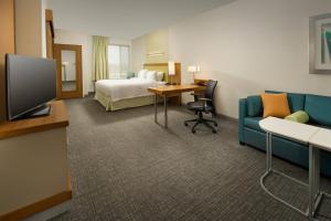 布里奇波特布里奇波特克拉克斯堡春季山丘套房酒店的酒店客房配有1张床、1台电视和1张沙发。