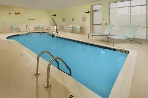 布里奇波特布里奇波特克拉克斯堡春季山丘套房酒店的一个带桌椅的大型游泳池