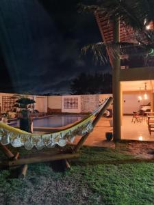 考卡亚Casa Ferreira Cumbuco的夜间游泳池前的吊床