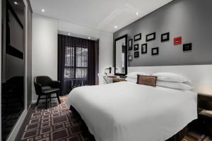 比勒陀利亚比勒陀利亚门林普罗蒂亚火与冰万豪酒店的酒店客房,配有白色的床和椅子