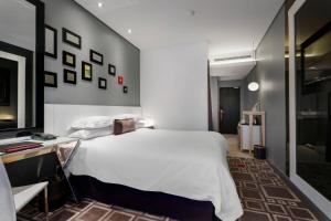 比勒陀利亚比勒陀利亚门林普罗蒂亚火与冰万豪酒店的卧室配有一张白色大床和一张书桌