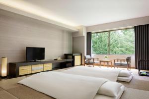 山中湖村山中湖富士万豪酒店的一间大卧室,配有一张大床和一台电视