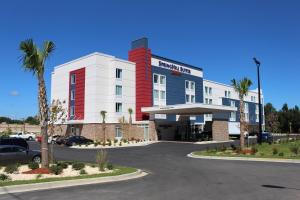 萨姆特萨姆特万豪春季山丘套房酒店的拥有红色和白色建筑的酒店,设有停车场