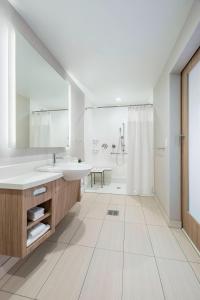 麦迪逊SpringHill Suites Madison的白色的浴室设有水槽和淋浴。