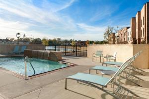 里奇兰杰克逊北/里奇兰万豪斯普林希尔套房酒店的庭院设有带椅子和桌子的游泳池。