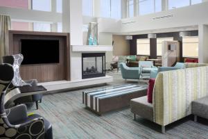 利特尔顿Residence Inn by Marriott Denver Southwest/Littleton的大堂设有壁炉、椅子和电视。
