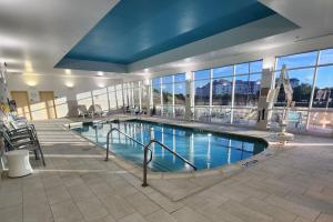 普莱诺达拉斯普莱诺/弗里斯科万豪春丘套房酒店的大型建筑内的大型游泳池,设有窗户