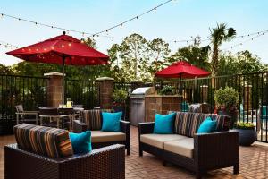 贝敦TownePlace Suites by Marriott Houston Baytown的庭院里设有椅子和遮阳伞