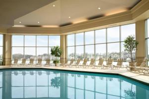 印第安纳波利斯Marriott Indianapolis North的游泳池,带椅子和窗户