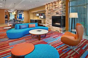 圣约翰斯Fairfield Inn & Suites by Marriott St. John's Newfoundland的客厅设有蓝色的沙发和壁炉