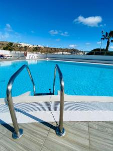 波多黎各Peace and View Apartment Puerto Rico的游泳池前面设有长凳