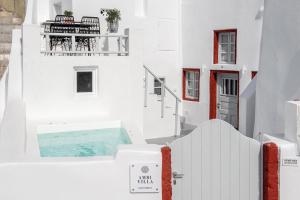 伊亚Ambi Villas Santorini的享有带游泳池的白色建筑的景致