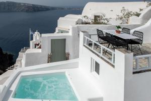 伊亚Ambi Villas Santorini的一个带桌子和游泳池的阳台