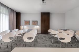 科斯拉达科斯拉达机场万豪AC酒店的一间会议室,配有白色的椅子和桌子