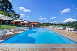 塞拉内格拉Filimahalo Hotel的度假村的游泳池配有椅子和遮阳伞