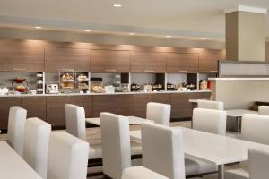 斩魔山TownePlace Suites by Marriott Outer Banks Kill Devil Hills的用餐室配有白色的桌子和白色的椅子