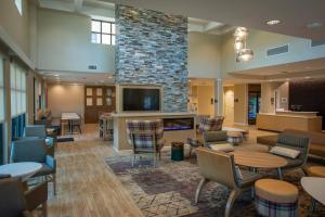 彭萨科拉Residence Inn by Marriott Pensacola Airport/Medical Center的大堂设有壁炉和桌椅。