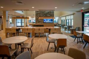 彭萨科拉Residence Inn by Marriott Pensacola Airport/Medical Center的一间带桌椅的餐厅和一间酒吧