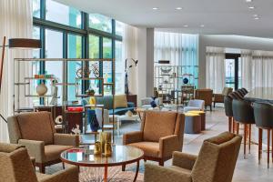 萨拉索塔Art Ovation Hotel, Autograph Collection的大堂设有桌椅和窗户。