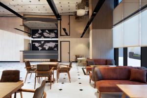 伊斯坦布尔Residence Inn by Marriott Istanbul Atasehir的餐厅设有桌椅和投影屏幕