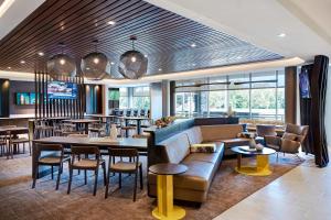 堪萨斯城SpringHill Suites Kansas City Airport的一间带沙发和桌椅的餐厅
