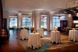 梅泰里新奥尔良梅泰里莱克威万豪酒店的宴会厅配有桌椅和桌子。