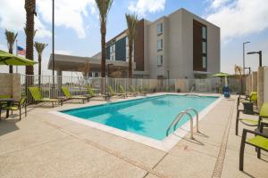 嘉年SpringHill Suites by Marriott Phoenix Goodyear的一座带椅子的游泳池以及一座建筑