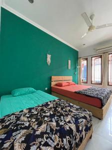 TimuranGorga hostel的卧室设有两张床铺和绿色的墙壁
