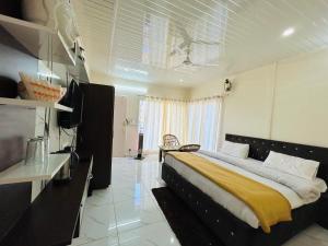 卡纳塔尔IN APPLE ESTATE KANATAL - Himalayan View Resort with Courteous Staff的一间卧室配有一张带黄色毯子的大床