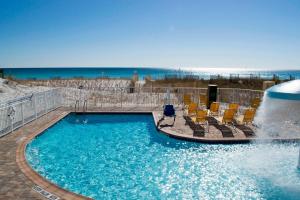 沃尔顿堡滩沃尔顿堡滩西德斯坦万豪费尔菲尔德套房酒店的一个带椅子的游泳池以及一个喷泉