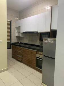普特拉贾亚CheeAyu@ Putrajaya IOI Resort的厨房配有白色橱柜和不锈钢冰箱