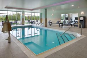 奥里利亚Fairfield by Marriott Inn & Suites Orillia的一座配有桌椅的酒店游泳池