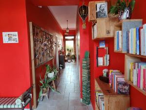 阿尔贝罗贝洛Art Rooms Joyful People的走廊上设有红色的墙壁和书架