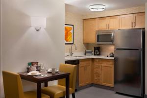马卡姆Residence Inn by Marriott Toronto Markham的厨房配有桌子和不锈钢冰箱。
