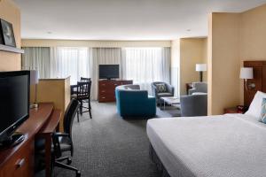 萨克拉门托万豪萨克拉门托加州展览中心万怡酒店的酒店客房设有床和客厅。
