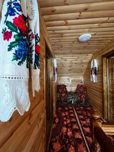 舒加塔格盐矿镇Rustic Maramureș的木房里设有一张床和椅子的房间