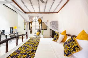 迪亚尼海滩Zarafa House的客房配有白色的床和黄色枕头