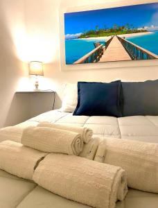 切法卢Carbonari Holiday House的一间客房配有两张带毛巾的床和一张海滩照片