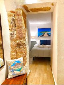 切法卢Carbonari Holiday House的一间卧室设有一张床和石墙